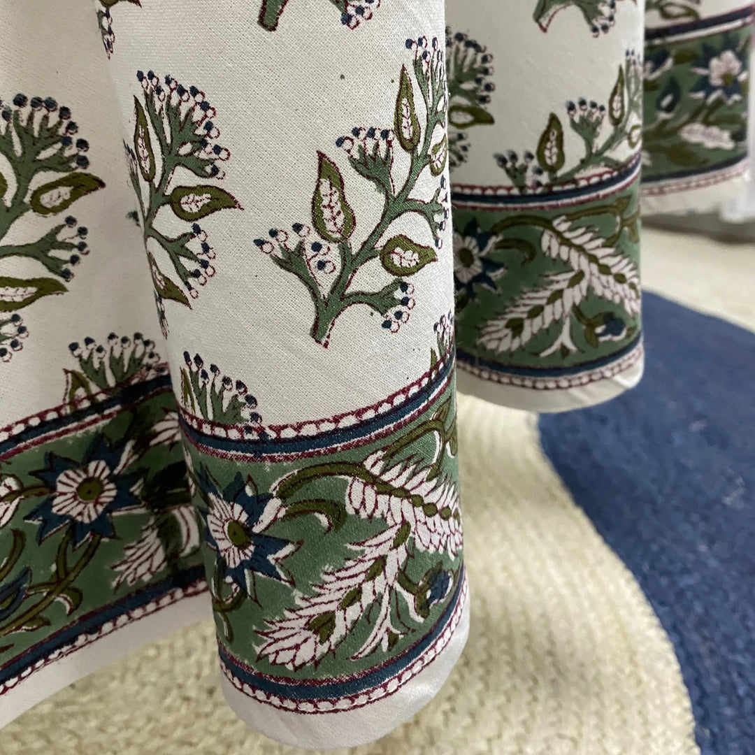 Close-up of patterned fabric with floral and leaf designs on a white background.