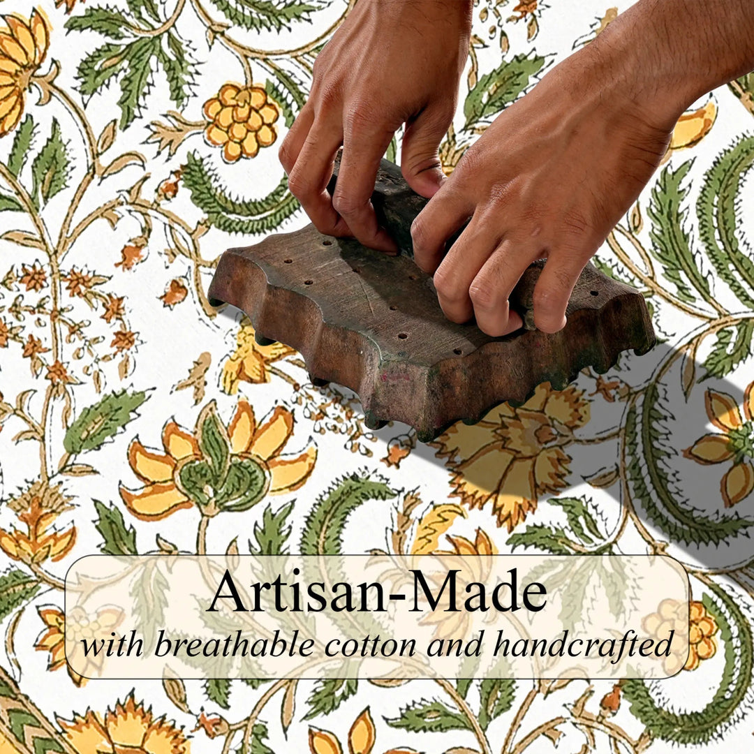 Hands using a traditional printing block on fabric with floral patterns and &