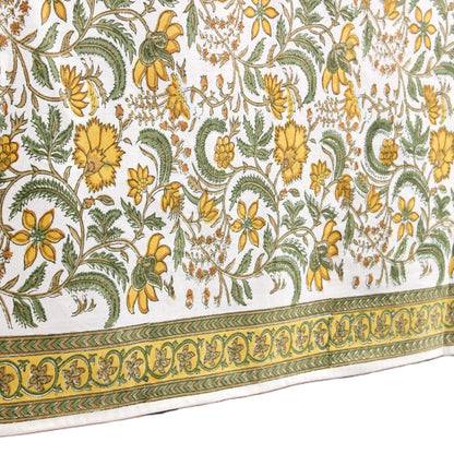 Floral patterned fabric with yellow and green flowers on a white background