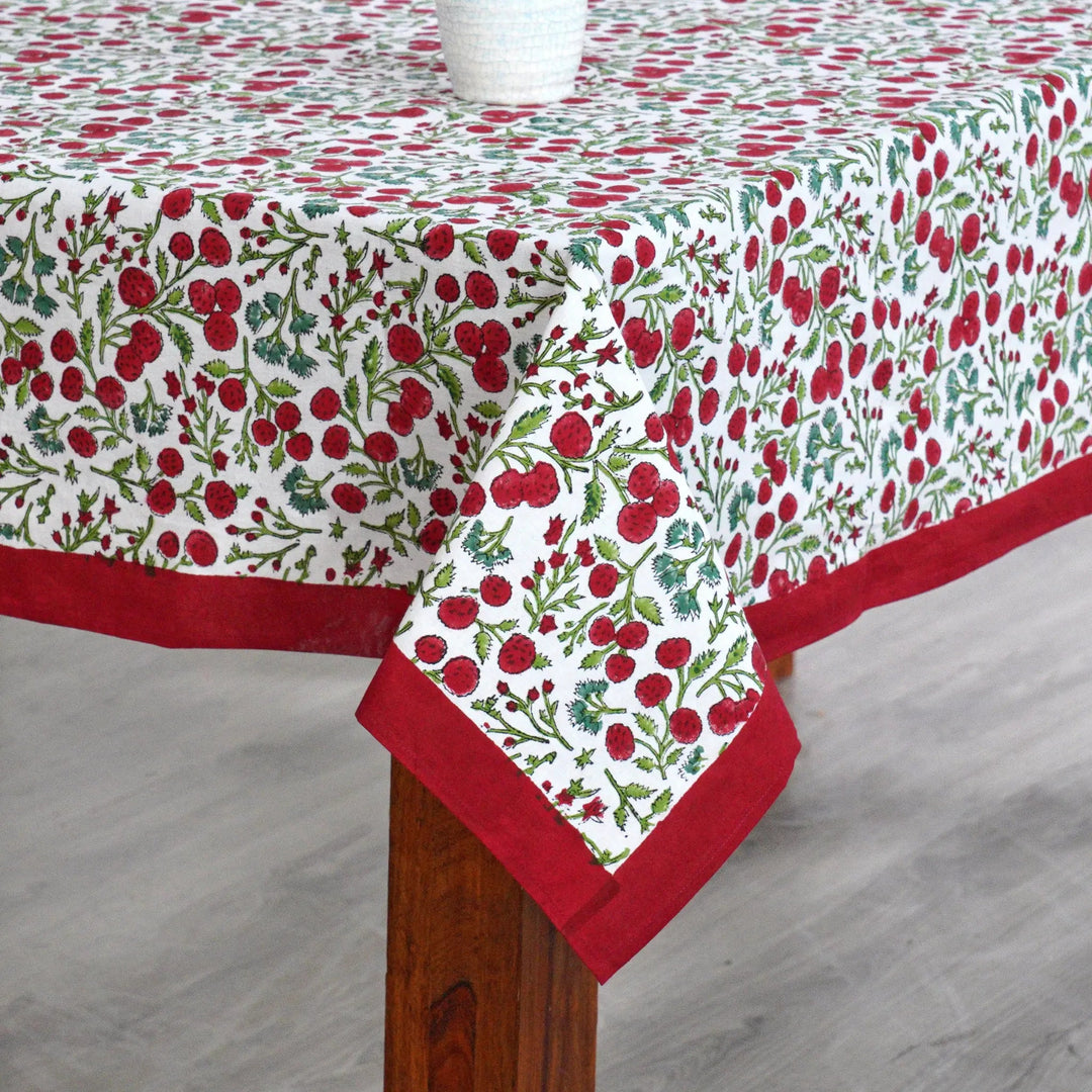 Tablecloth with red and green floral pattern on a wooden table