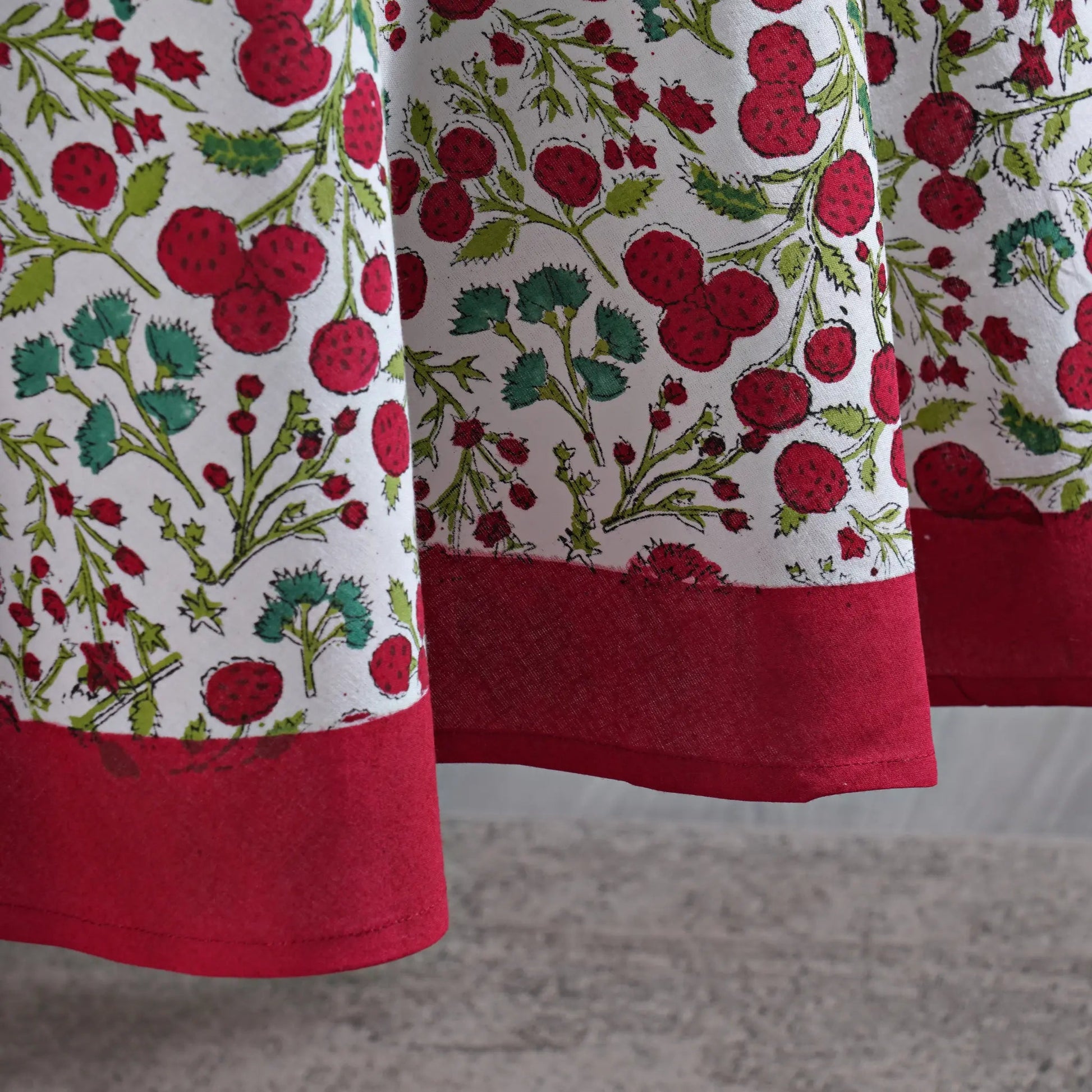 Close-up of a fabric with red berry pattern on a white background