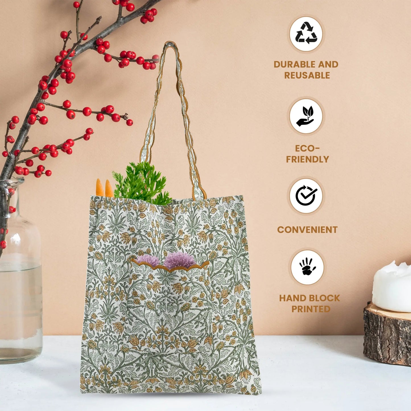 Floral-patterned tote bag with vegetables, next to a branch with red berries and a candle on a white surface.