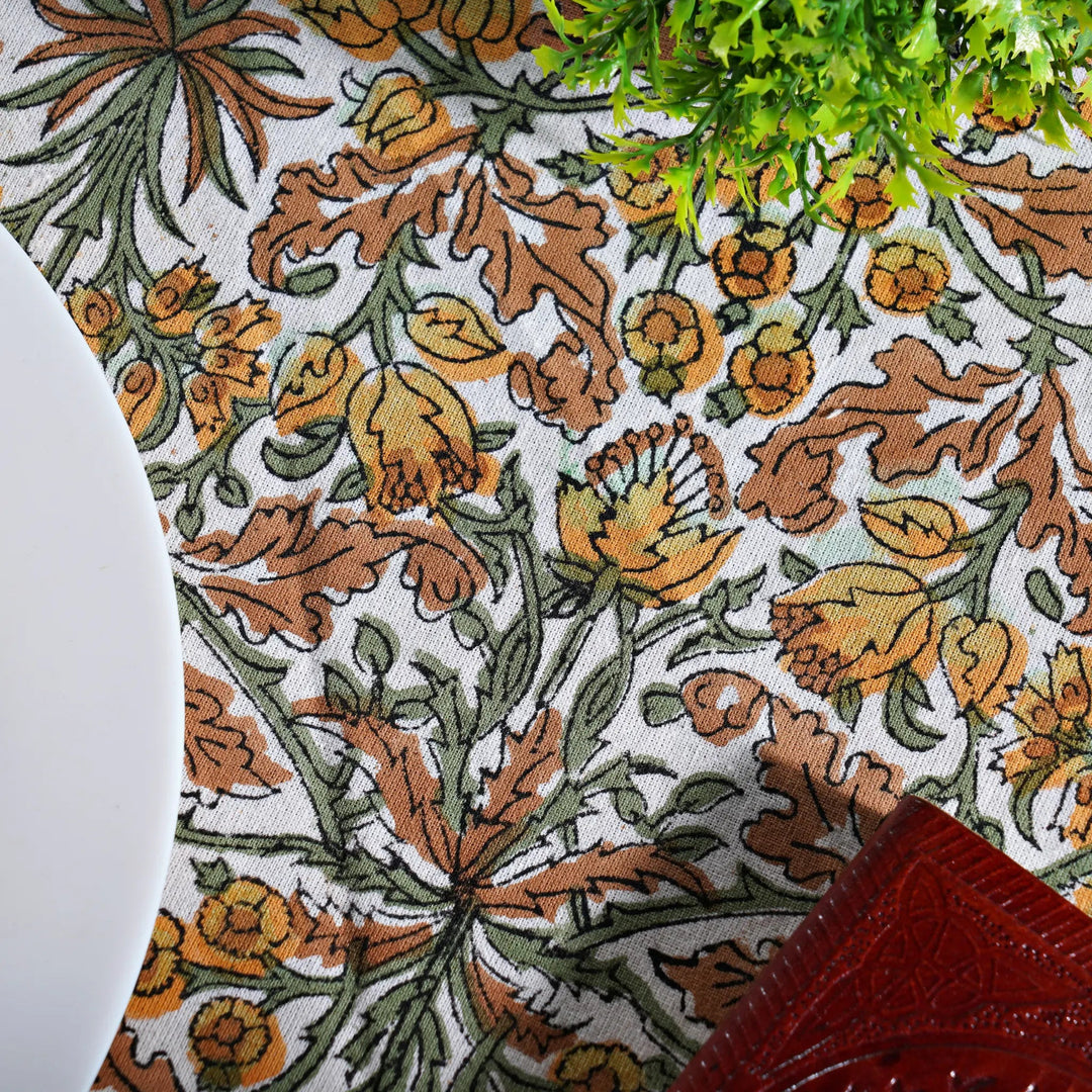 Close-up of a floral patterned fabric with brown, green, and orange colors.
