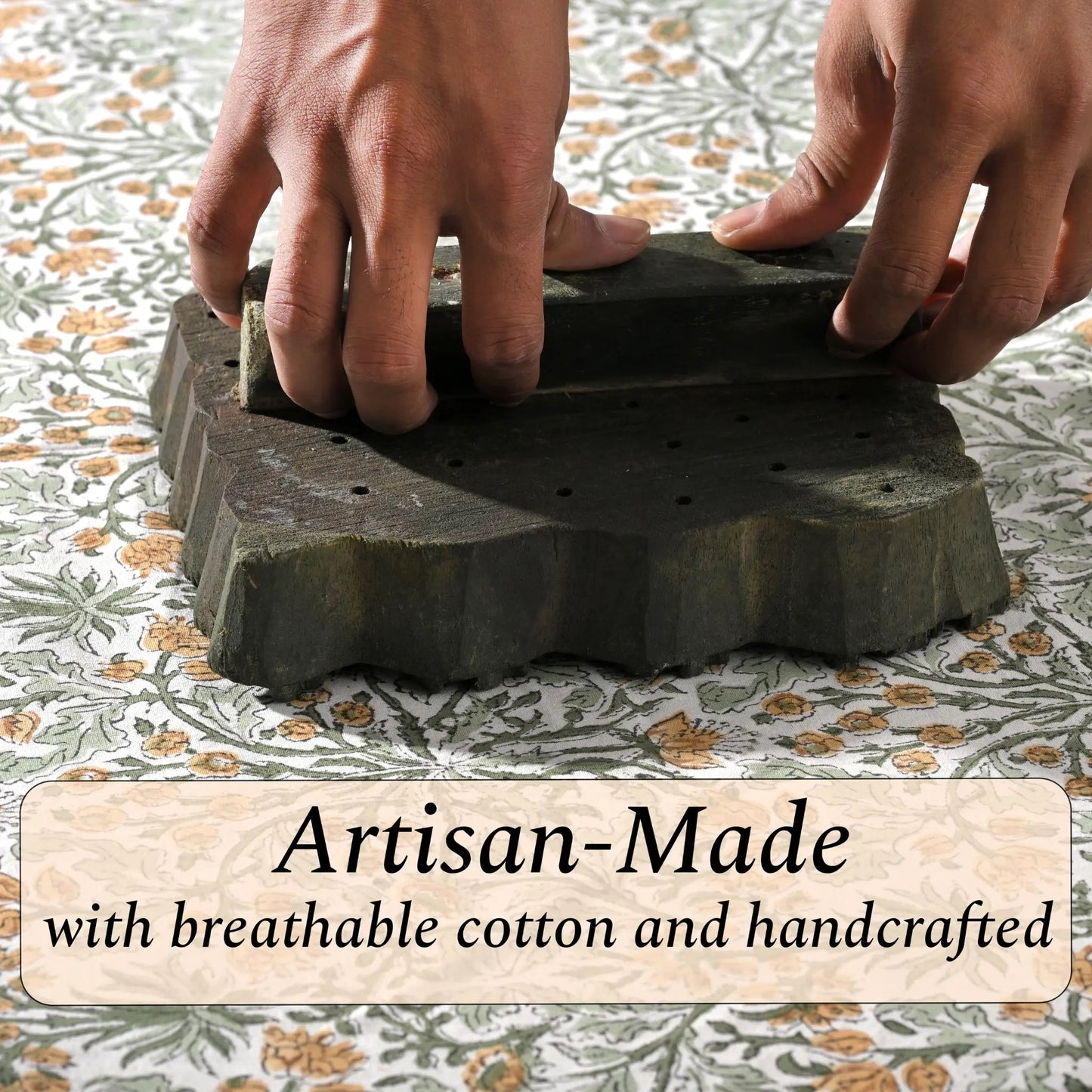 Hands holding a stack of artisan-made stone slabs with text on a patterned fabric background