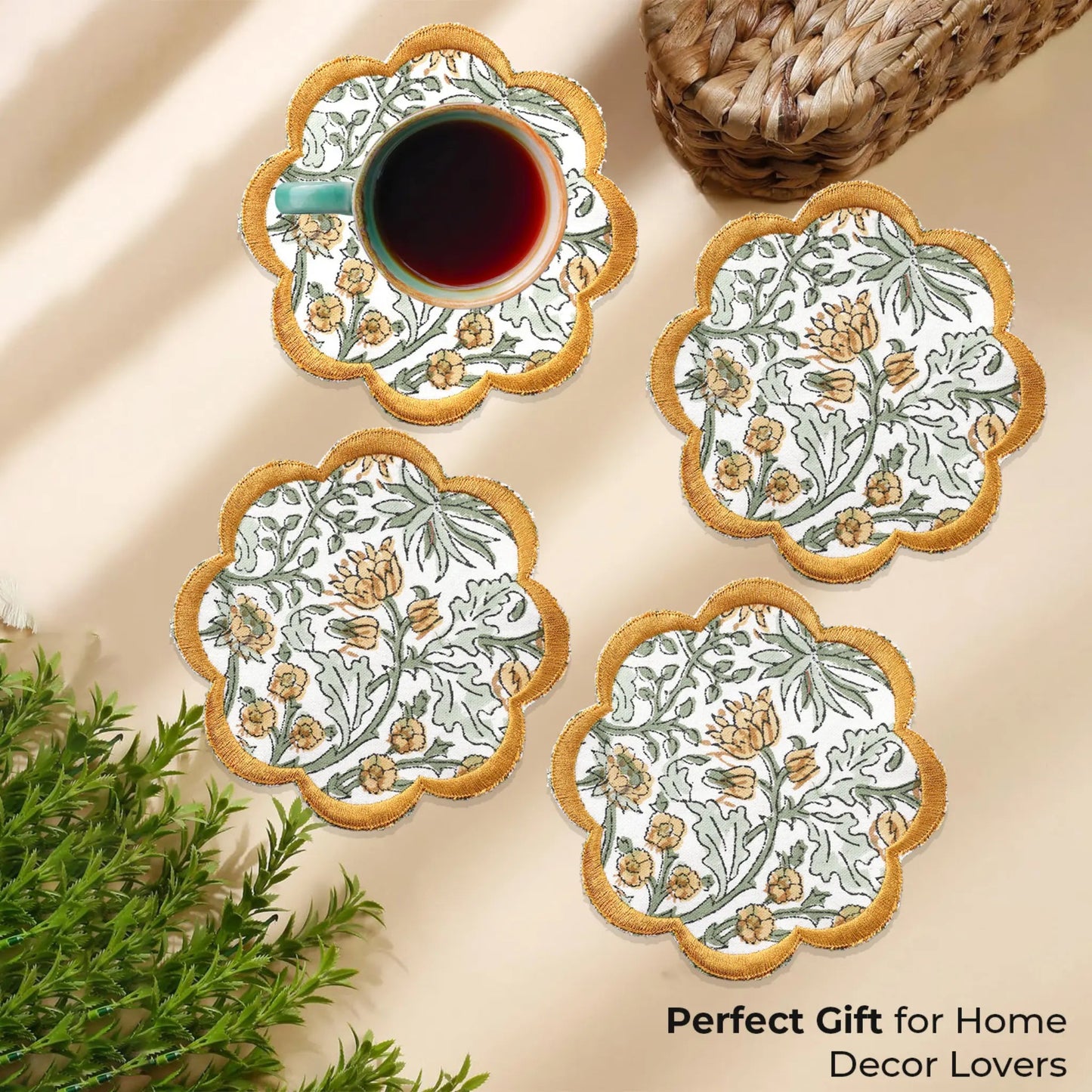 Set of four floral coasters with a cup of tea on a beige surface.