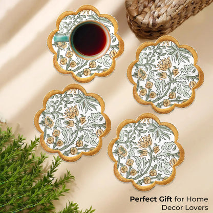 Set of four floral coasters with a cup of tea on a beige surface.