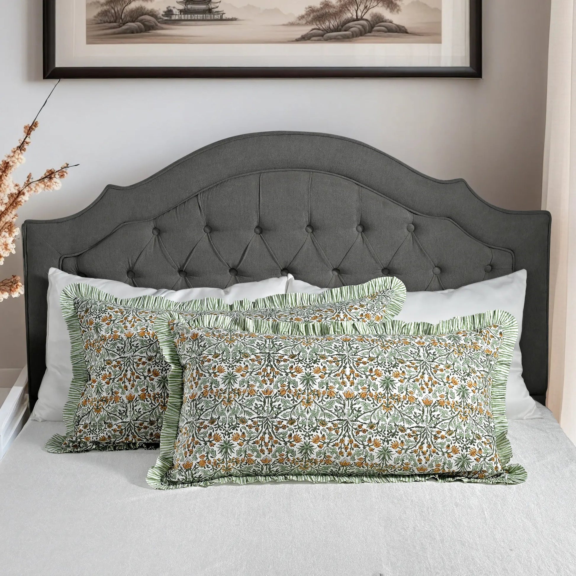 Large block print cotton pillows styled on gray upholstered bed.