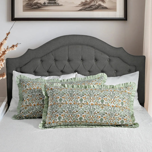 Large block print cotton pillows styled on gray upholstered bed.