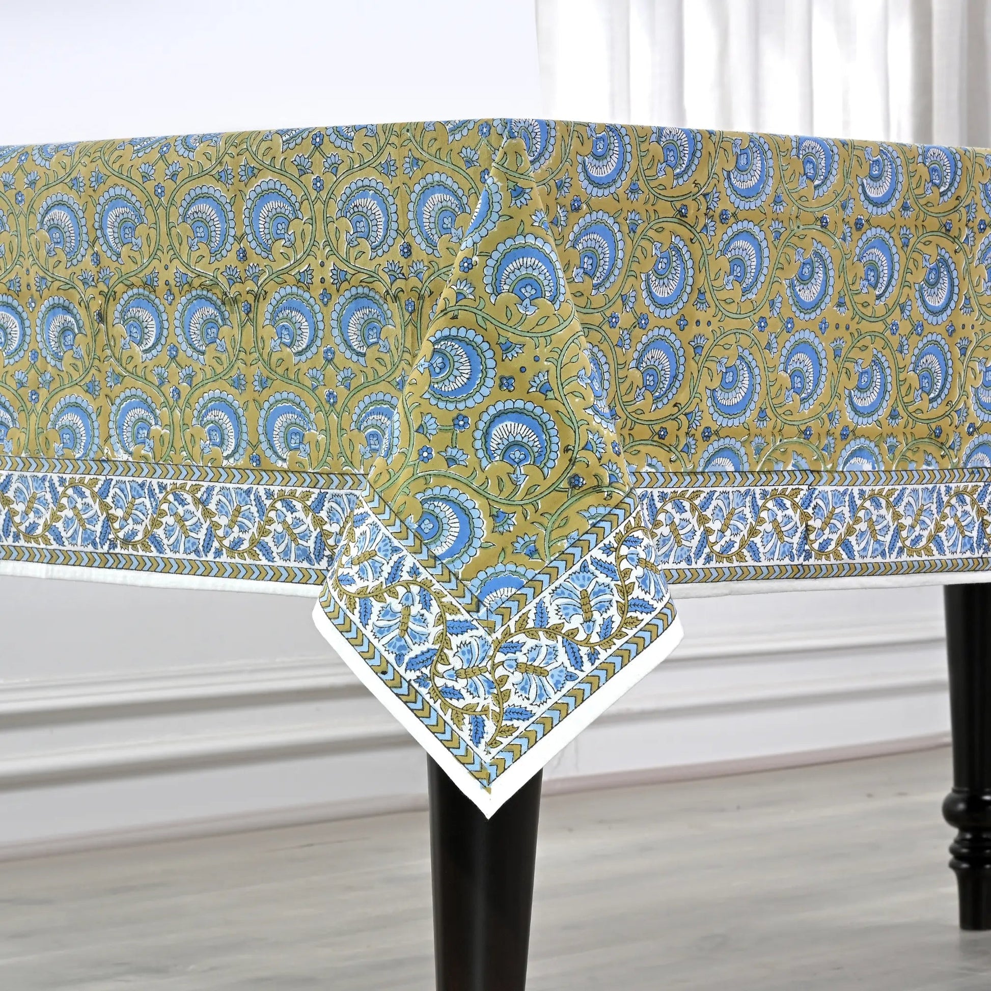 Patterned tablecloth on a table with a white curtain background