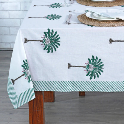 Tablecloth with green floral patterns on a wooden table.