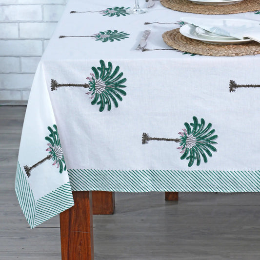 Tablecloth with green floral patterns on a wooden table.