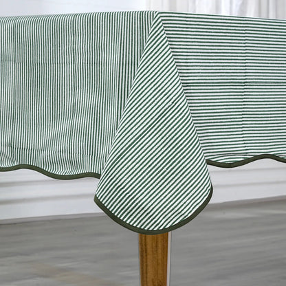 Green and white striped tablecloth on a wooden table with a neutral background
