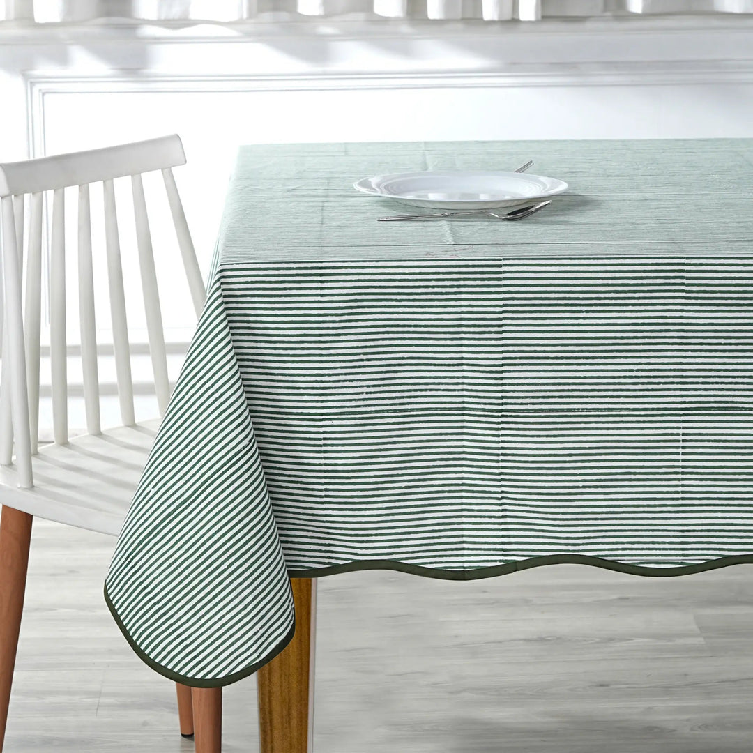 Tablecloth with green stripes on a wooden table and white chair