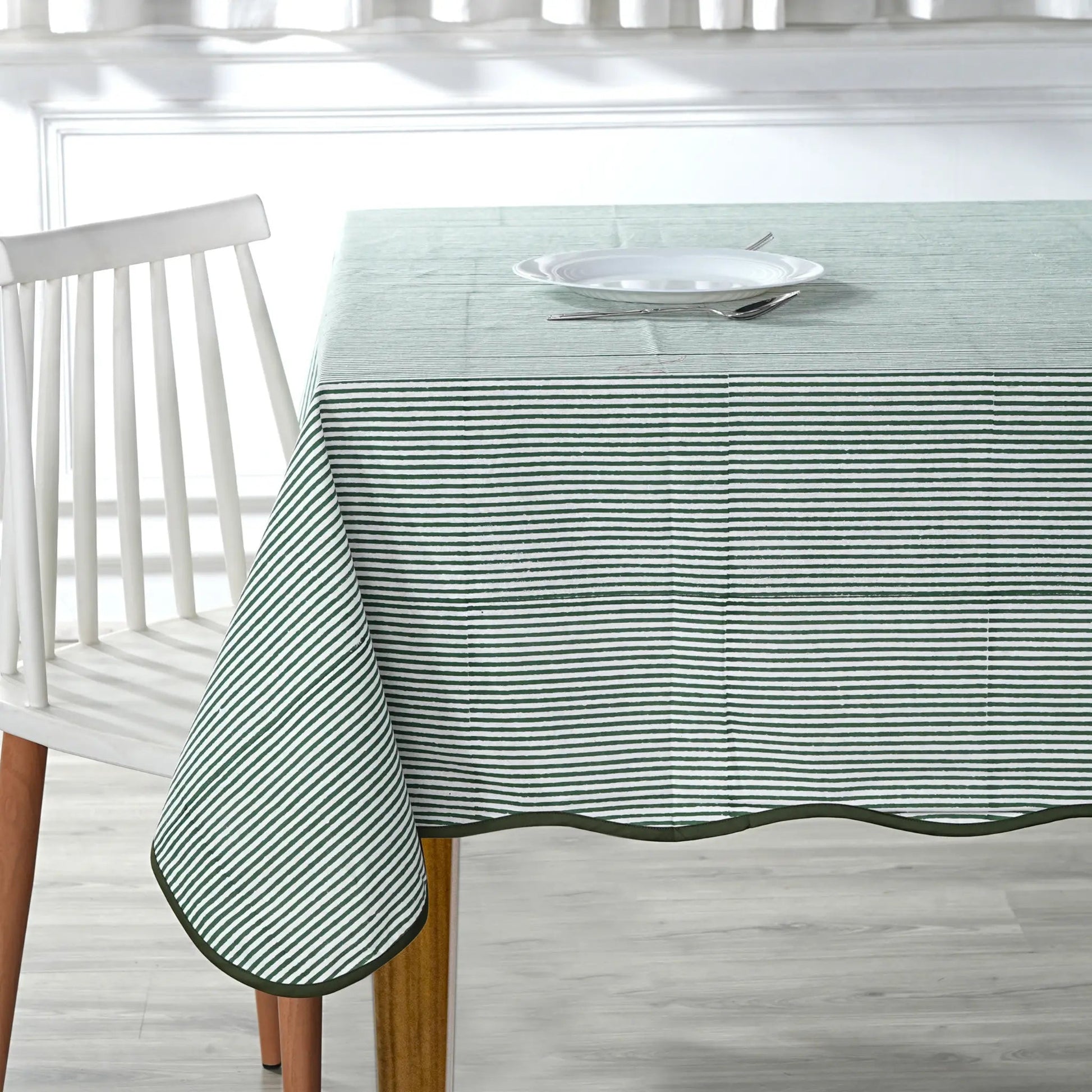 Tablecloth with green stripes on a wooden table and white chair