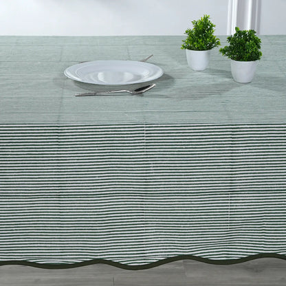Tablecloth with black stripes on a table setting with a plate, cutlery, and plants.