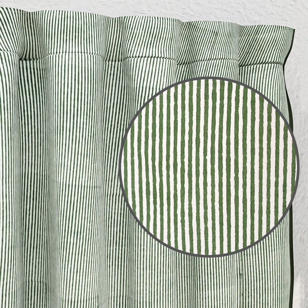 Green and white striped fabric with a close-up of a circular section.