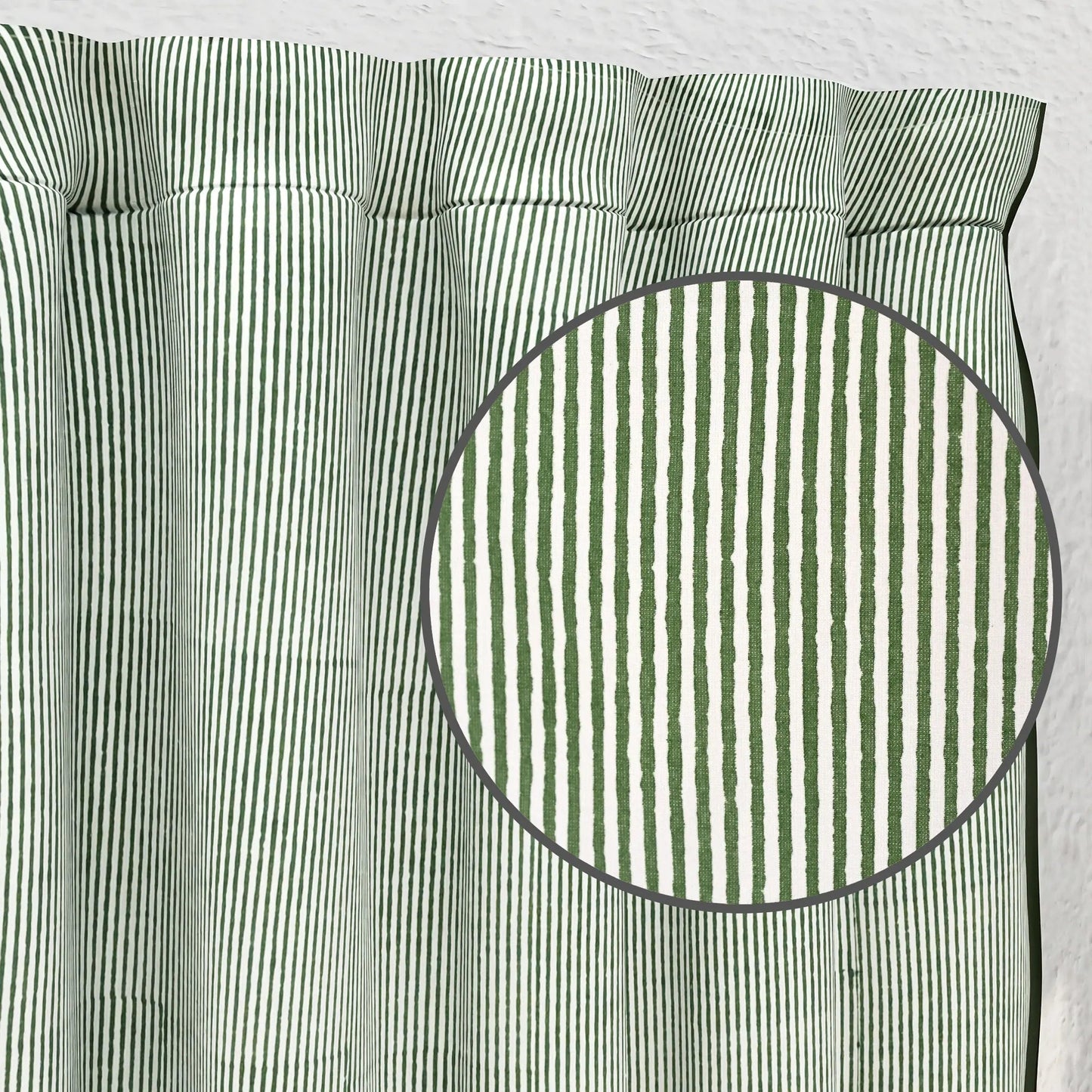Green and white striped fabric with a close-up of a circular section.