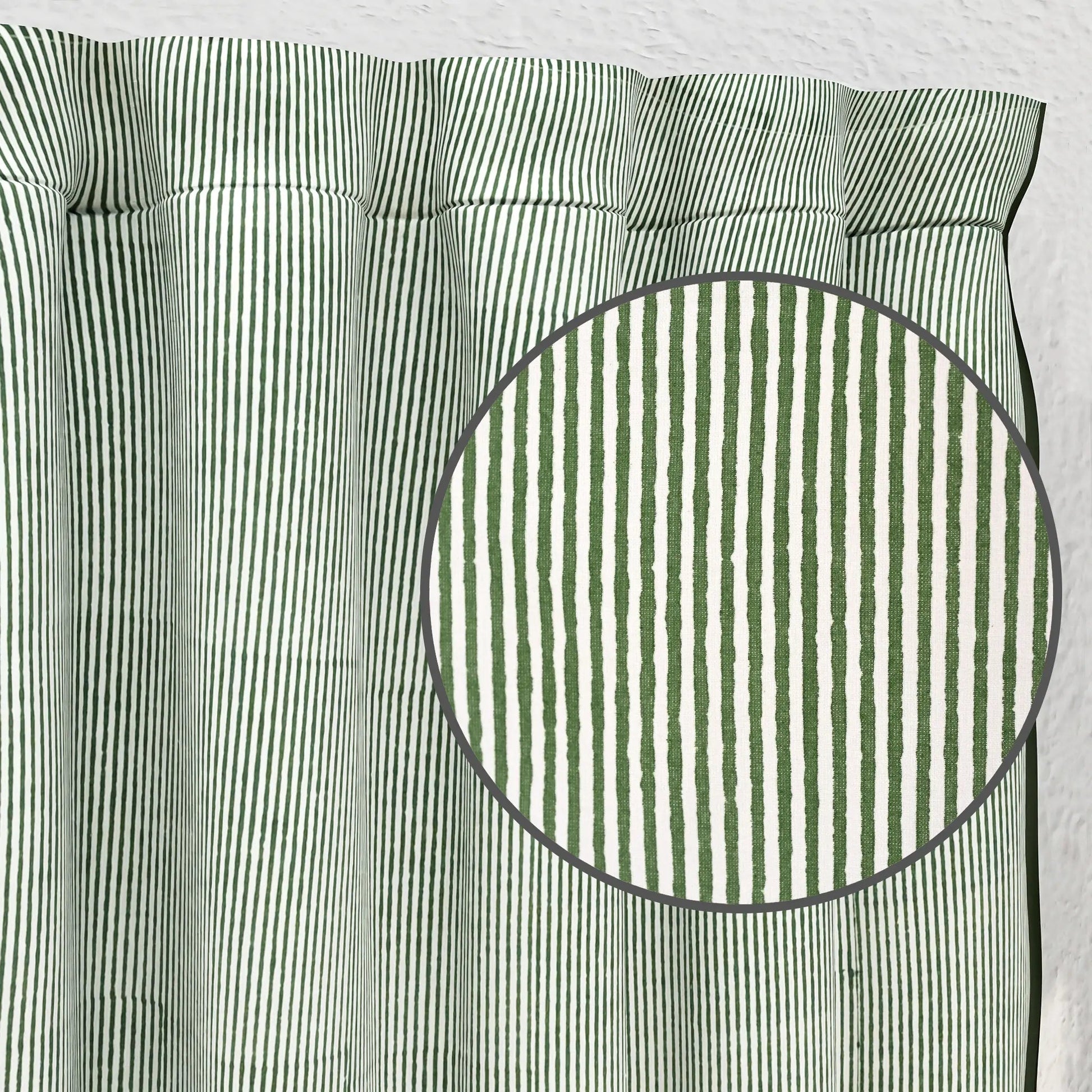 Green and white striped fabric with a close-up of a circular section.