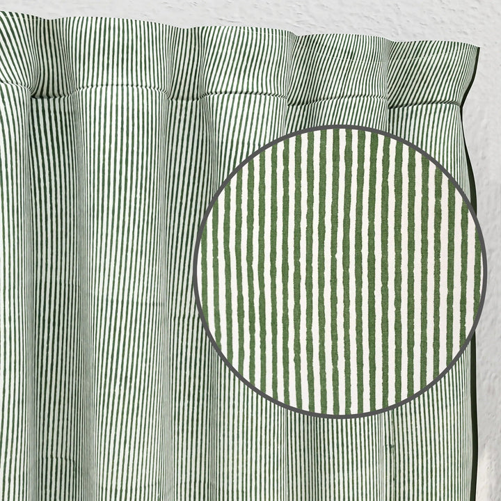 Green and white striped fabric with a close-up of a circular section.