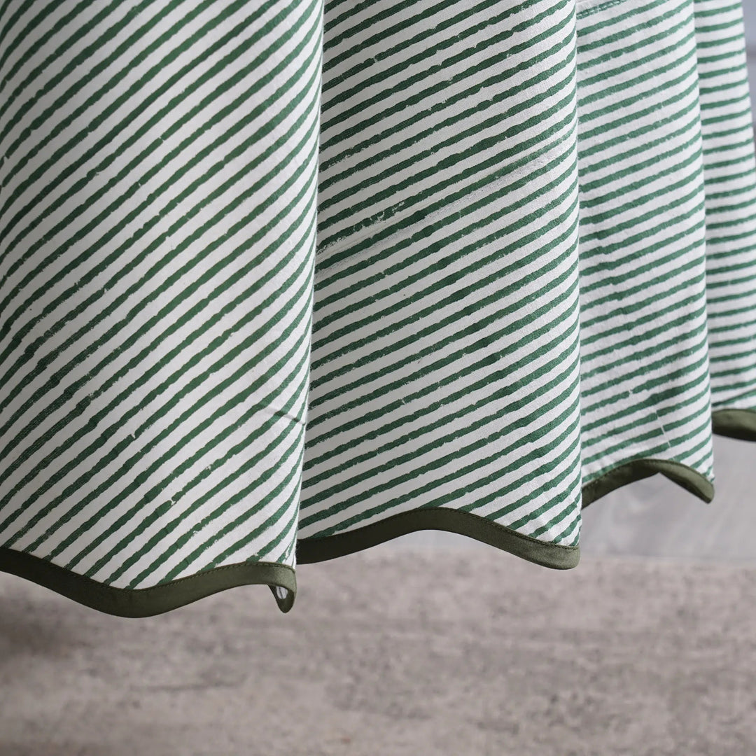 Green and white striped fabric with a textured pattern on a neutral background
