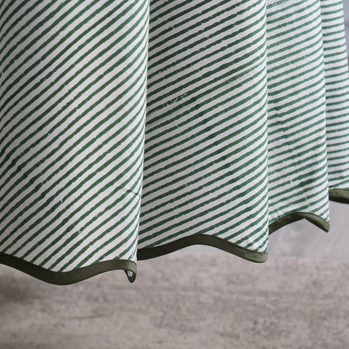 Green and white striped fabric with a textured pattern on a neutral background