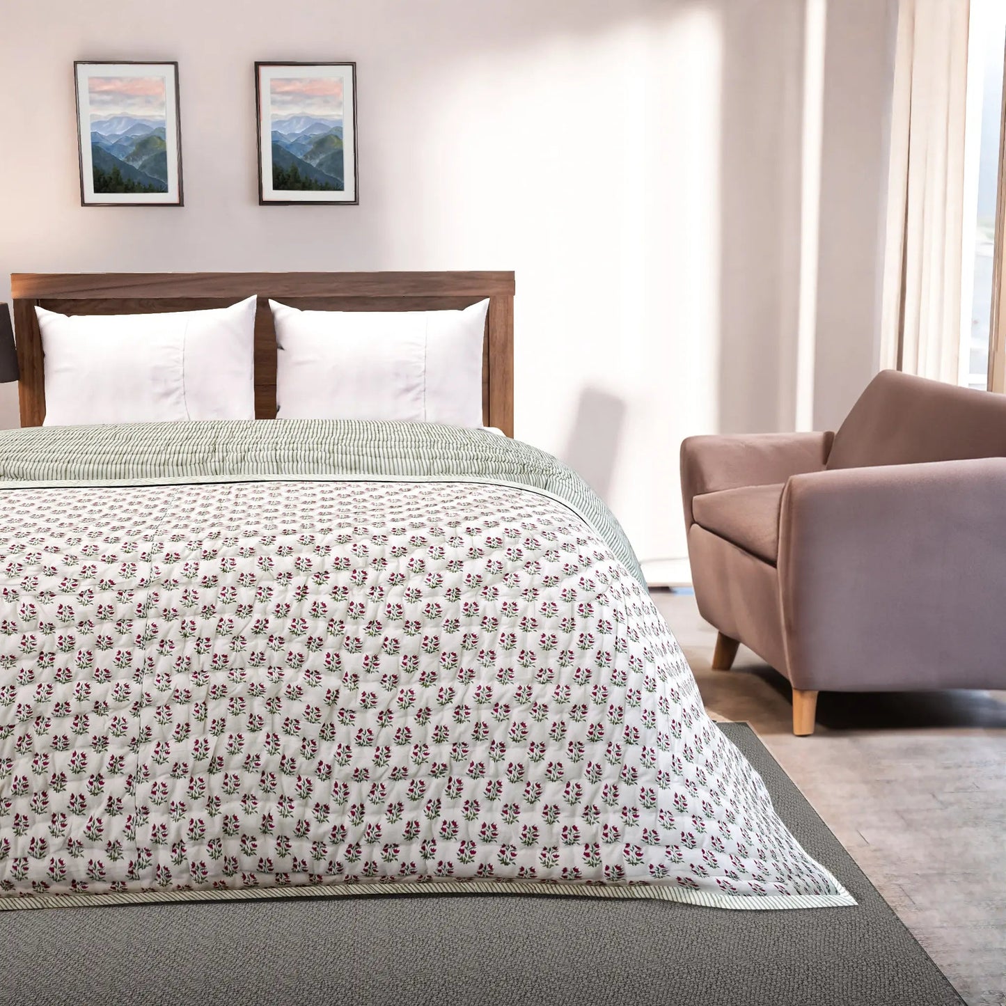Bedroom with a bed featuring a floral-patterned comforter, a chair, and framed pictures on the wall.
