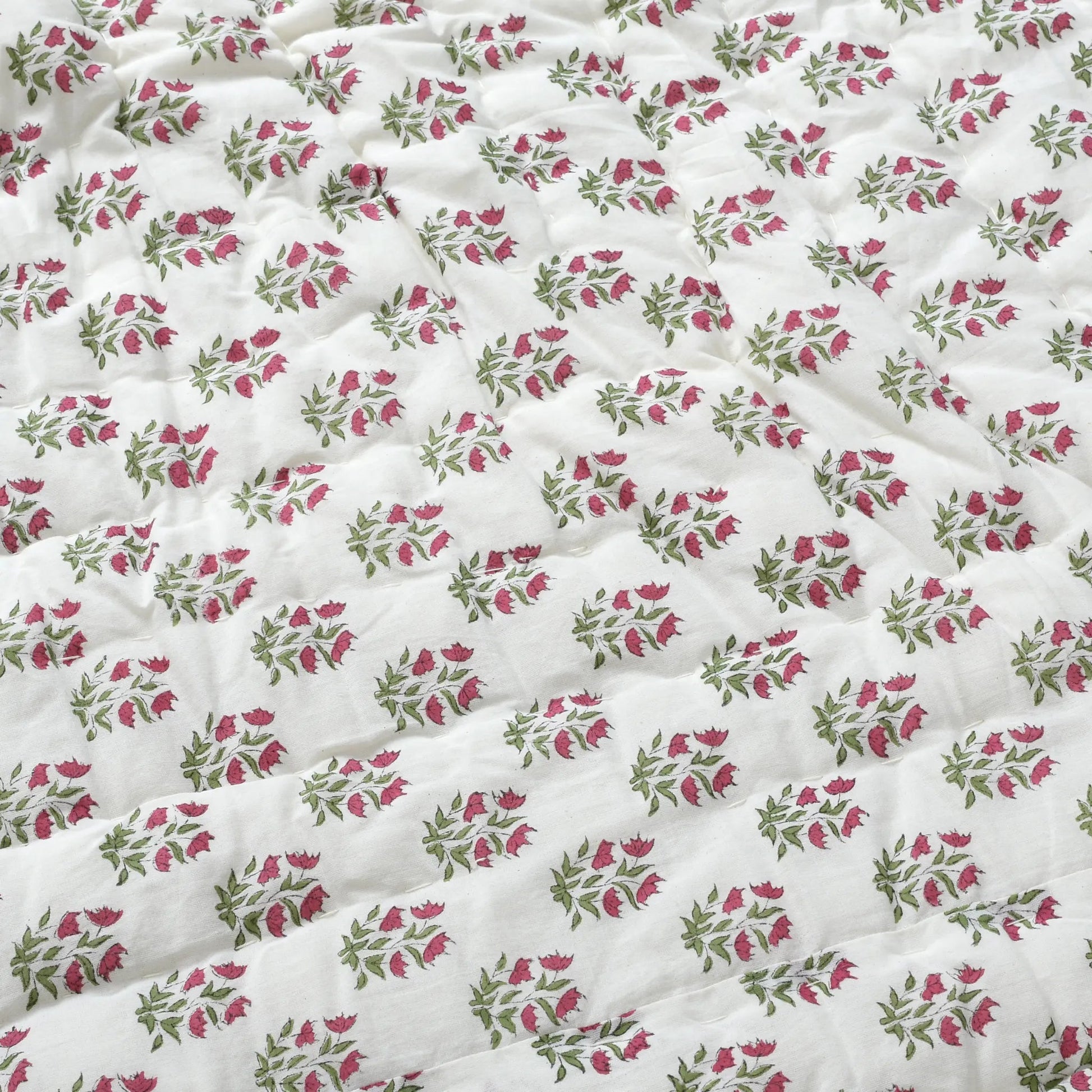 Floral patterned fabric with pink and green flowers on a white background