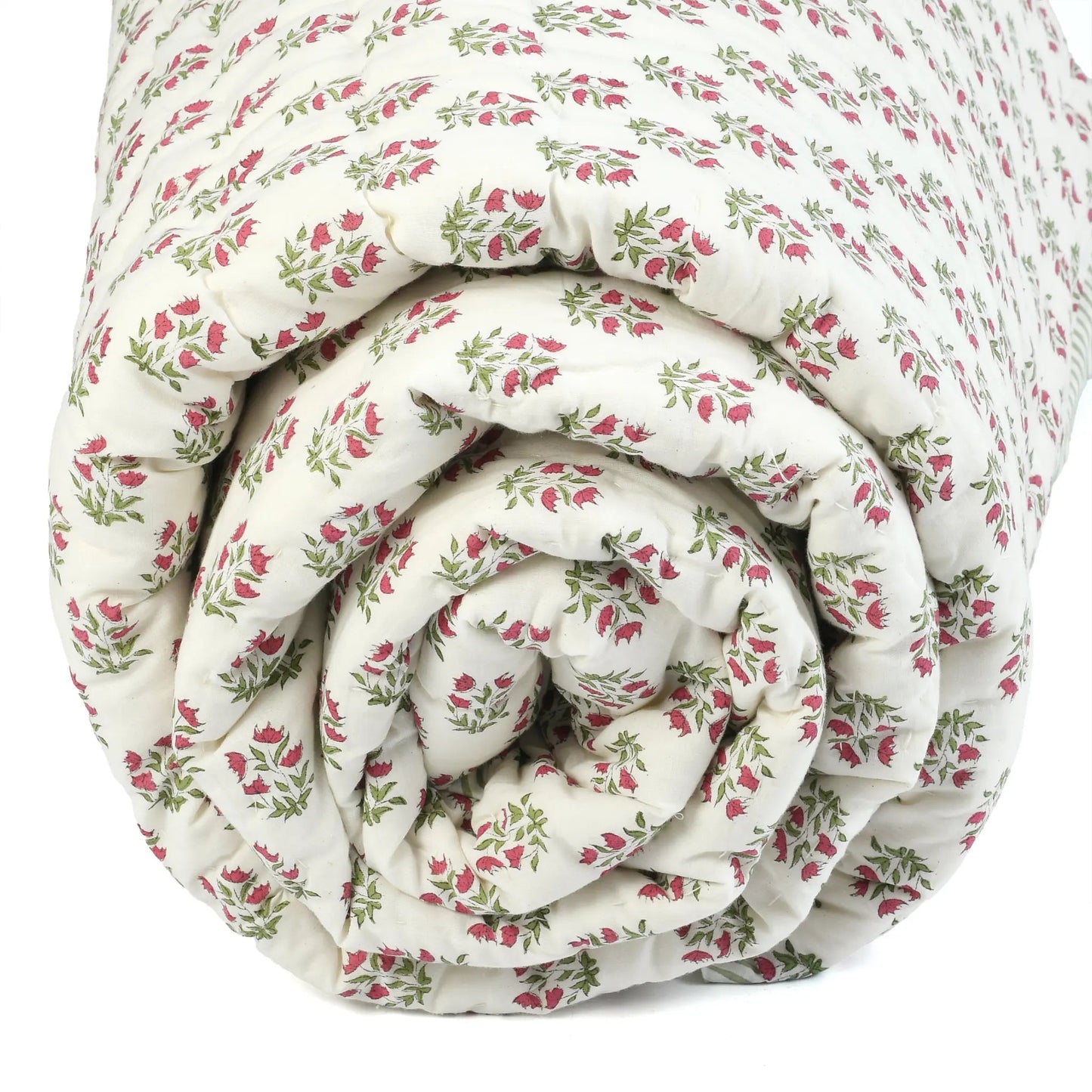 Rolled-up floral-patterned quilt on a white background