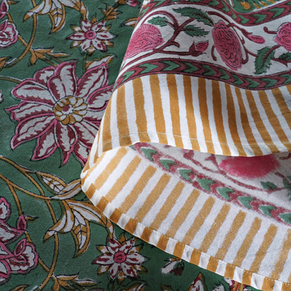 Close-up of patterned fabric with floral and striped designs on a green background