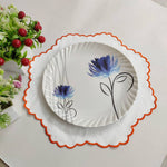 White linen round table mats with scallop edges in orange for table decor