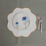 White linen round table mats with scallop edges in orange for table decor