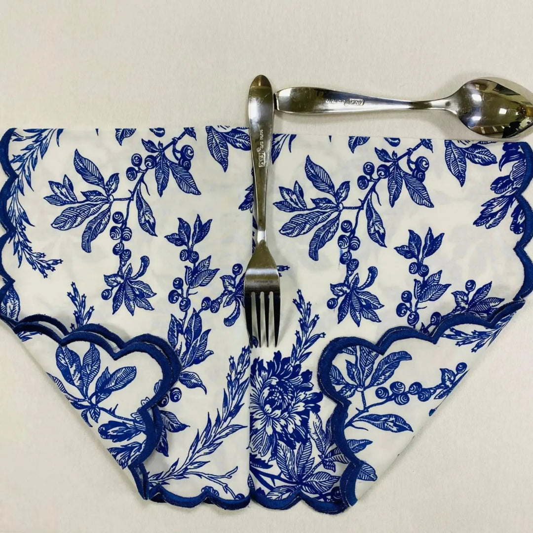 Napkin with blue floral pattern, fork, and spoon on a white background