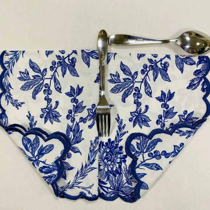 Napkin with blue floral pattern, fork, and spoon on a white background