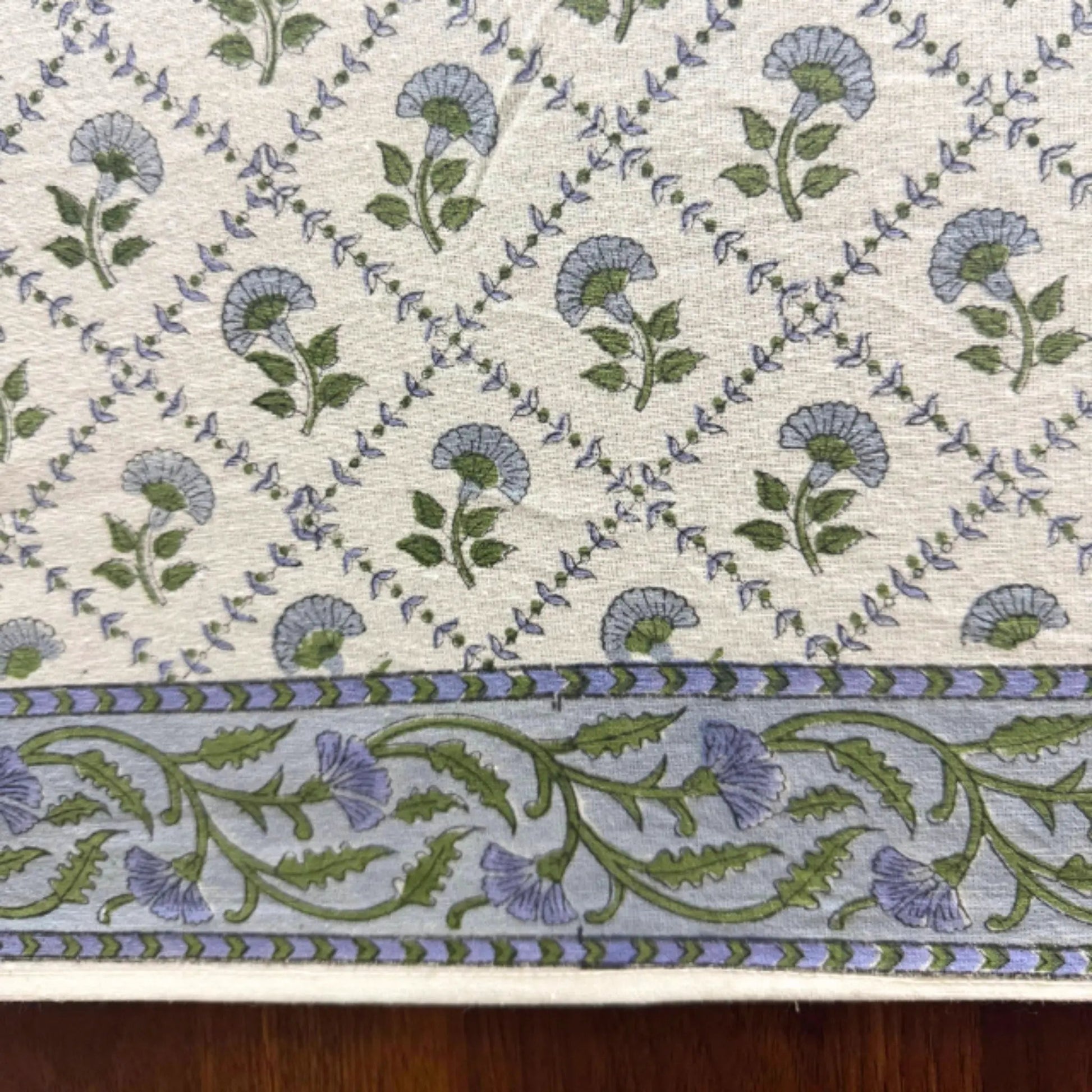 Floral patterned fabric with blue and green flowers on a beige background