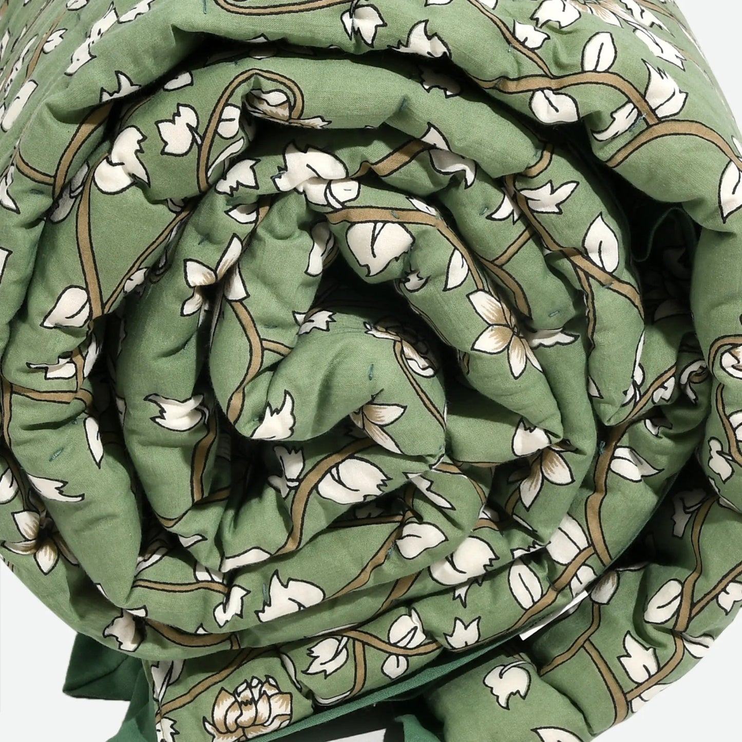 Rolled-up green fabric with white floral pattern on a white background