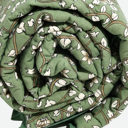 Rolled-up green fabric with white floral pattern on a white background