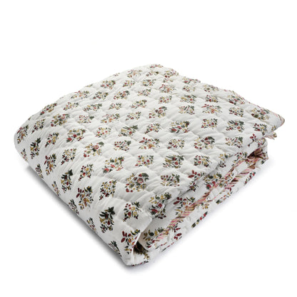 Floral patterned quilt on a white background