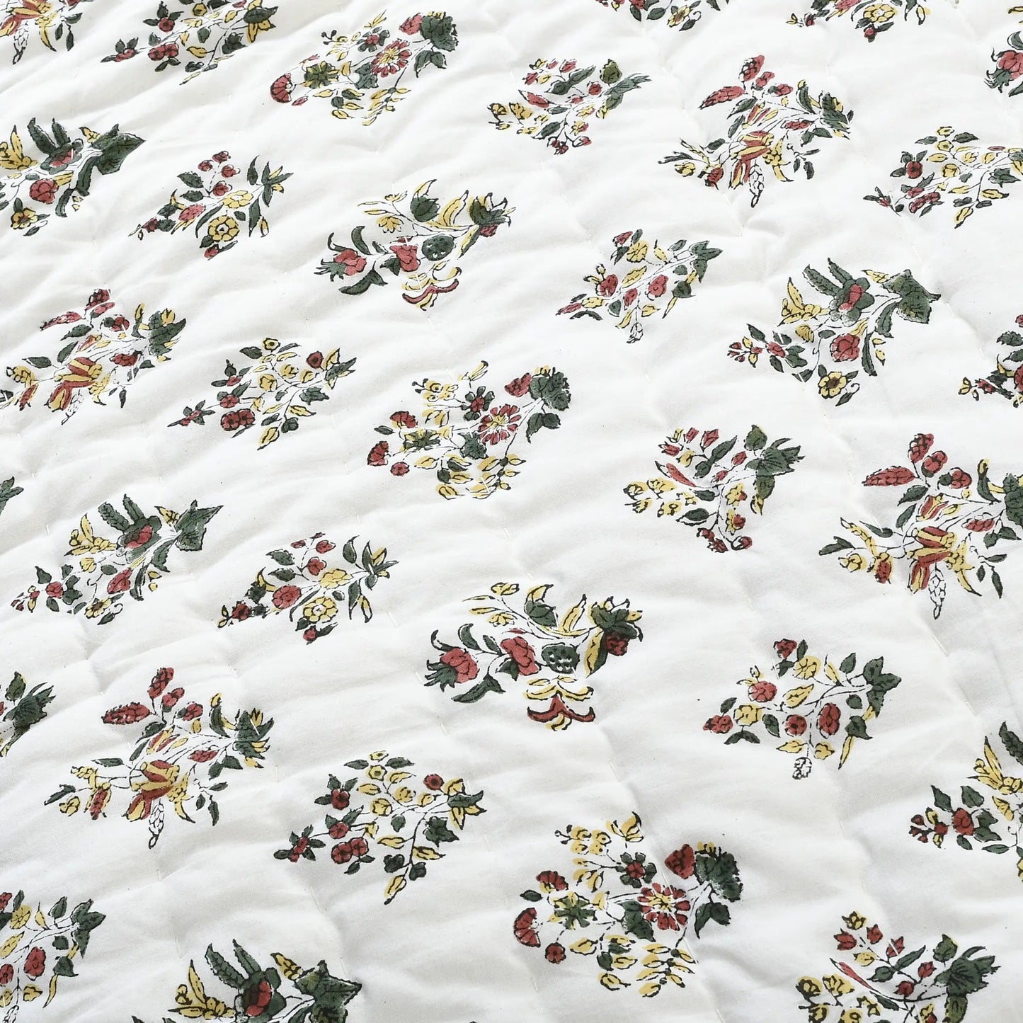 Floral patterned fabric with a quilted texture on a white background
