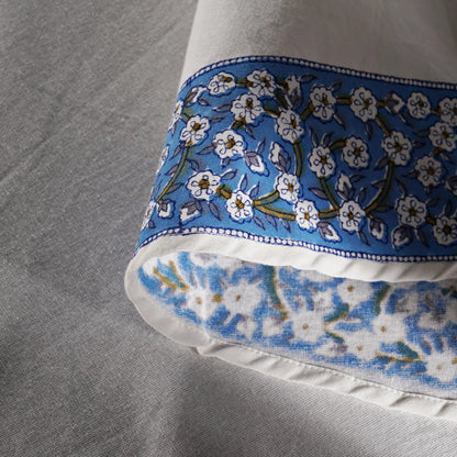 Close-up of a pillow with blue floral pattern on a gray fabric background