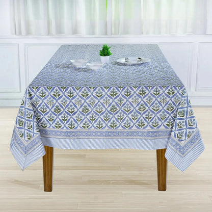 Tablecloth with geometric pattern on a wooden table in a room with white curtains.