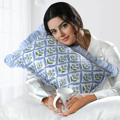 Woman holding a patterned pillow and a mug in a bedroom setting