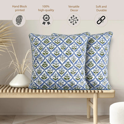 Two blue patterned pillows on a wooden bench with decorative elements.