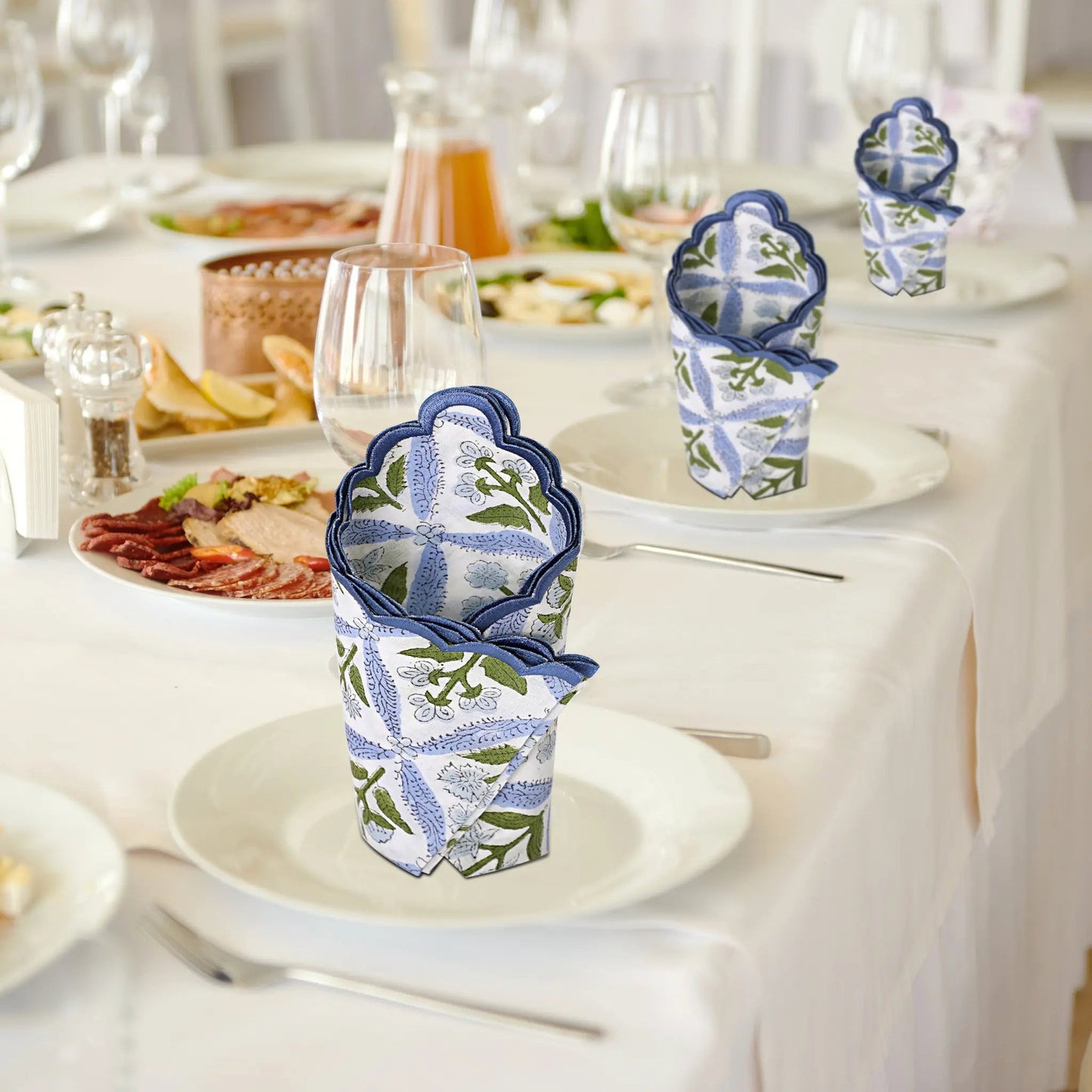 Decorative napkin holders on a table with plates and glasses