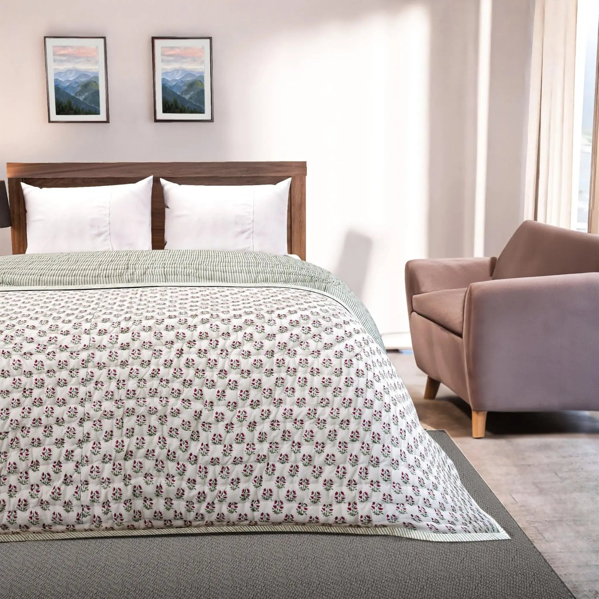 Bedroom with floral-patterned comforter on a bed, armchair, and framed pictures on the wall.