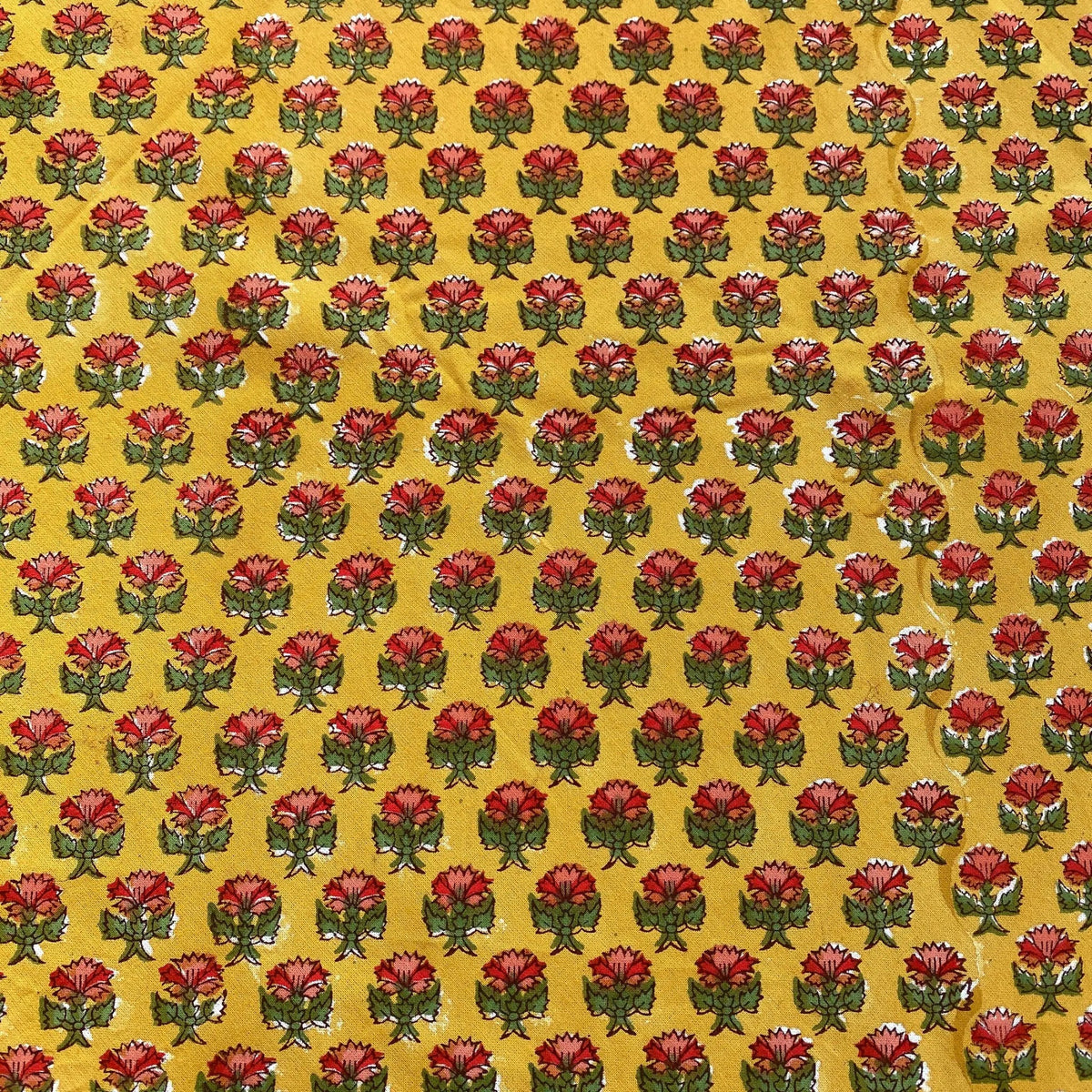 Pattern of red flowers with green stems on a yellow background