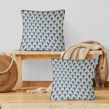 Two blue patterned cushions on a wooden stool with a neutral background