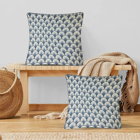 Two blue patterned cushions on a wooden stool with a neutral background