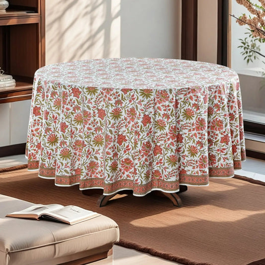 Round table with a floral patterned tablecloth in a living room setting.