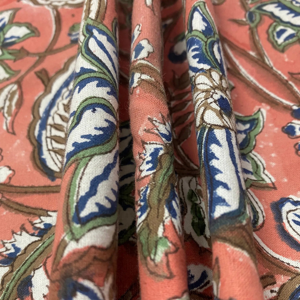 Close-up of patterned fabric with intricate design on a pink background