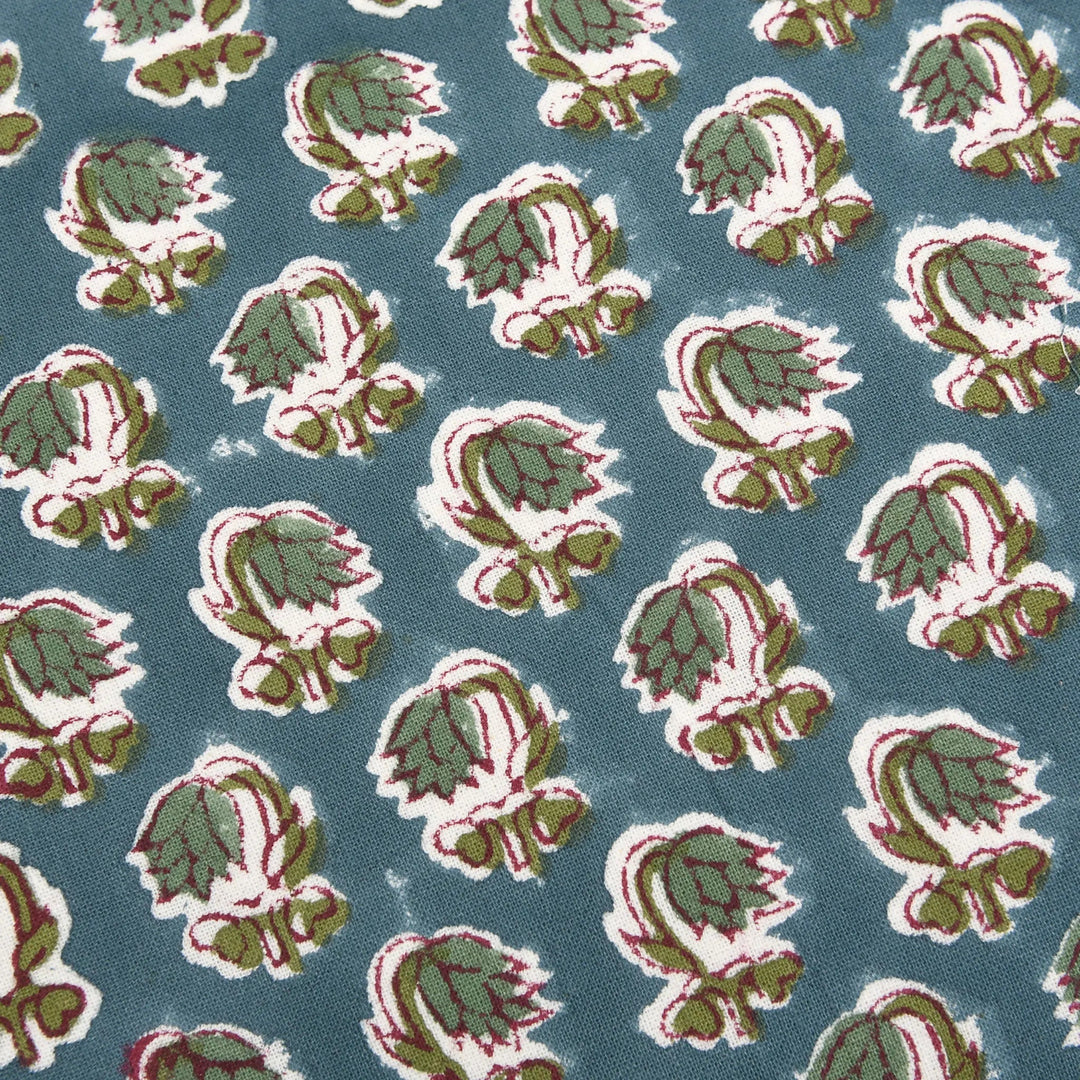 Pattern of green and red leaves on a blue background